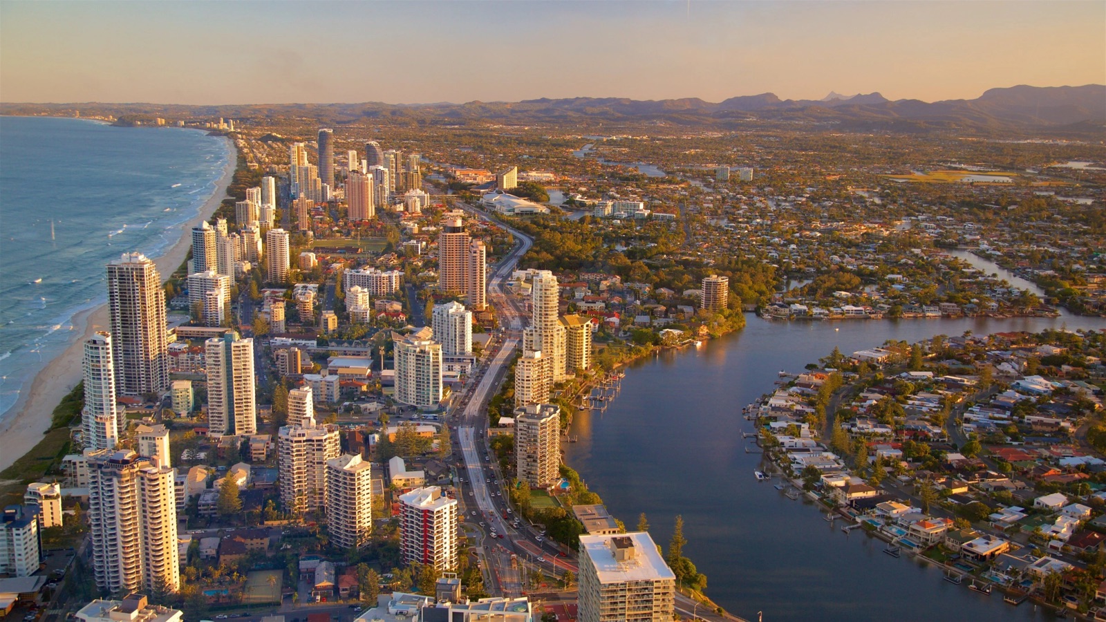 Aerial view of the Gold Coast at sunset, high-rises lining the beach beside the canals