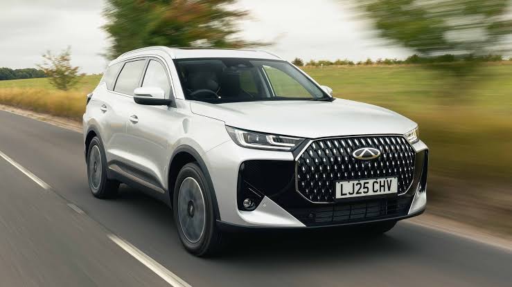 A silver SUV driving along a country road, the kind of car schools put up as a raffle prize